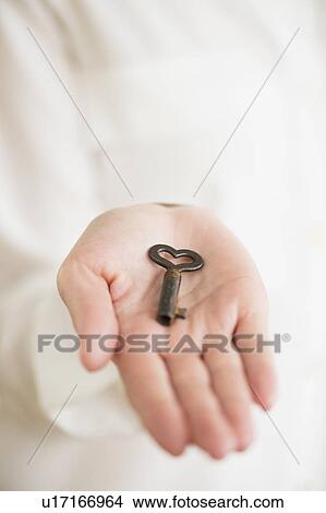 Female hand holding heart-shaped key View Large Photo Image Picture - Female hand holding heart-shaped key. Fotosearch