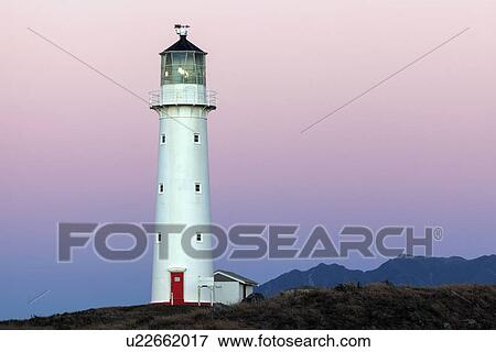 Stock Photo - Lighthouse with Taranaki volcano in background. Fotosearch