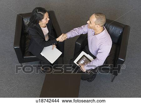 Man and woman at meeting in office seen from above View Large Photo Image Picture - Man and woman at meeting in office seen from above. Fotosearch