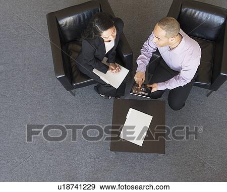 Stock Photo - Man and woman at meeting in office seen from above. Fotosearch