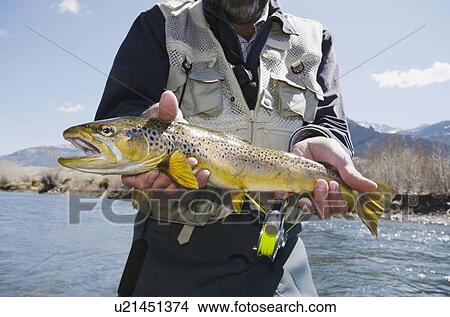 Picture - Man holding trout. Fotosearch