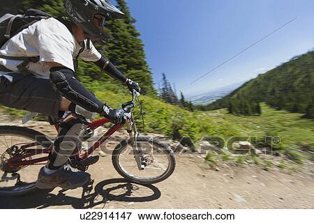 Stock Photo - Man mountain biking. Fotosearch