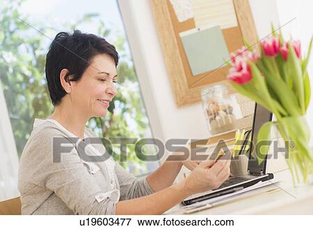 Mature woman doing online shopping View Large Photo Image Stock Photo - Mature woman doing online shopping. Fotosearch