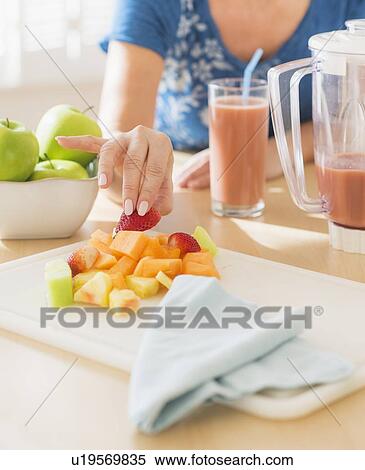 Stock Photography - Mature woman holding fruits. Fotosearch