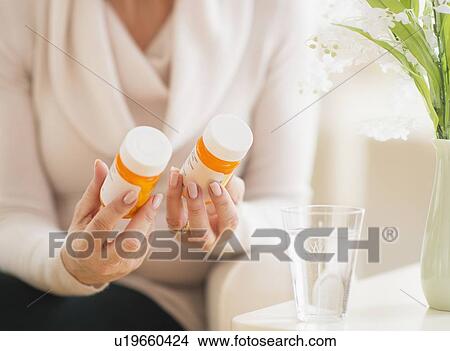 Mature woman holding pill bottles View Large Photo Image Picture - Mature woman holding pill bottles. Fotosearch