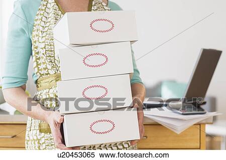 Stock Photography - Mid section of woman carrying boxes. Fotosearch