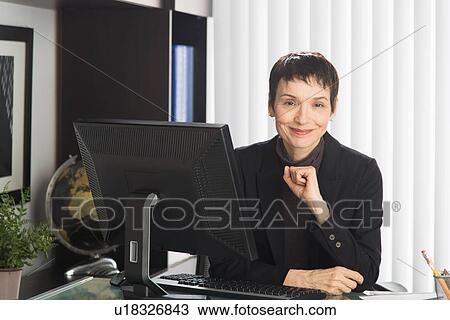 Portrait of businesswoman at desk View Large Photo Image Stock Image - Portrait of businesswoman at desk. Fotosearch
