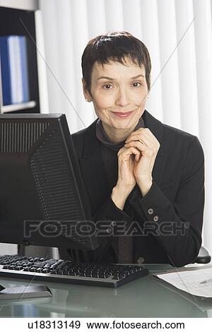 Stock Photo - Portrait of businesswoman at desk. Fotosearch