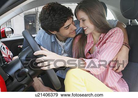 Stock Photo - Portrait of couple in car, man embracing woman. Fotosearch