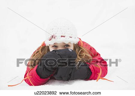 Stock Image - Portrait of girl (2-3) lying on snow. Fotosearch