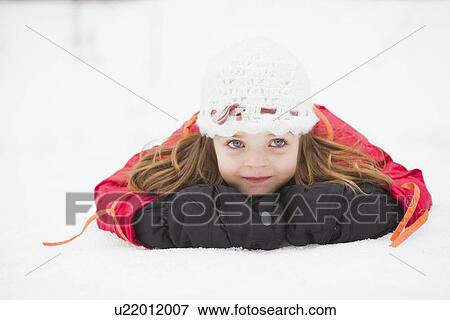 Stock Photo - Portrait of girl (2-3) lying on snow. Fotosearch