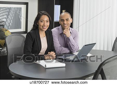 Stock Photo - Portrait of man and woman at meeting in office. Fotosearch