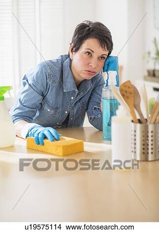 Picture - Portrait of mature woman cleaning kitchen. Fotosearch