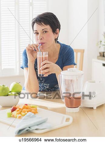 Picture - Portrait of mature woman drinking smoothie. Fotosearch