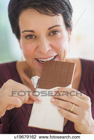Portrait of mature woman eating chocolate View Large Photo Image Stock Image - Portrait of mature woman eating chocolate. Fotosearch