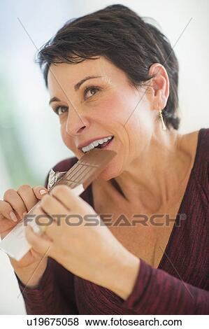 Portrait of mature woman eating chocolate View Large Photo Image Stock Photo - Portrait of mature woman eating chocolate. Fotosearch