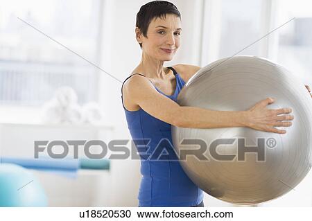 Portrait of mature woman exercising in gym View Large Photo Image Stock Image - Portrait of mature woman exercising in gym. Fotosearch