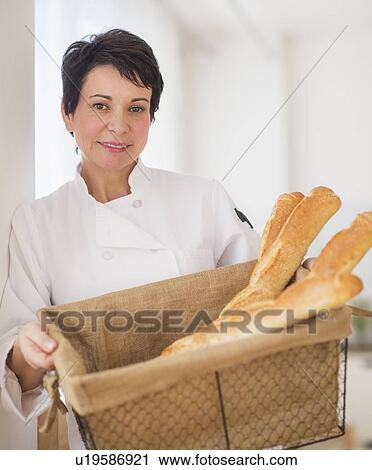 Portrait of mature woman holding basket with baguettes View Large Photo Image Stock Image - Portrait of mature woman holding basket with baguettes. Fotosearch