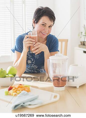 Portrait of mature woman holding smoothie View Large Photo Image Stock Photo - Portrait of mature woman holding smoothie. Fotosearch