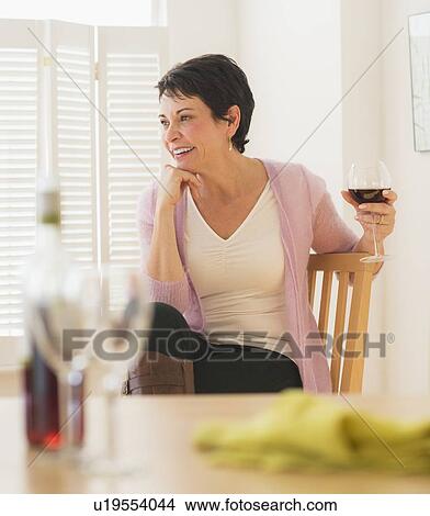 Picture - Portrait of mature woman holding wine glass. Fotosearch