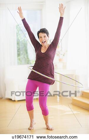 Portrait of mature woman hula-hooping View Large Photo Image Stock Image - Portrait of mature woman hula-hooping. Fotosearch