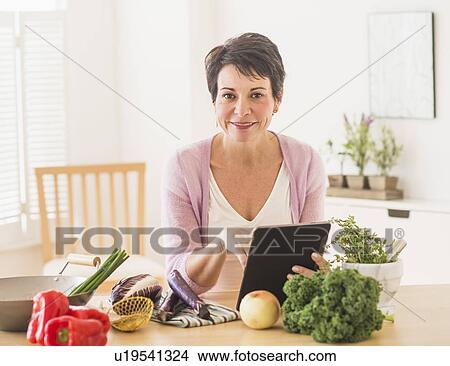 Portrait of mature woman in kitchen View Large Photo Image Picture - Portrait of mature woman in kitchen. Fotosearch