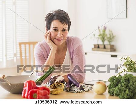 Portrait of mature woman in kitchen View Large Photo Image Stock Image - Portrait of mature woman in kitchen. Fotosearch
