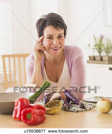 Portrait of mature woman in kitchen View Large Photo Image Stock Photo - Portrait of mature woman in kitchen. Fotosearch