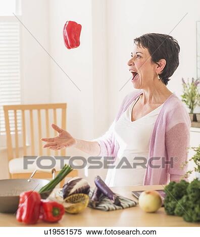 Stock Photography - Portrait of mature woman in kitchen. Fotosearch