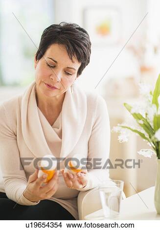 Portrait of mature woman looking at pill bottles View Large Photo Image Picture - Portrait of mature woman looking at pill bottles. Fotosearch