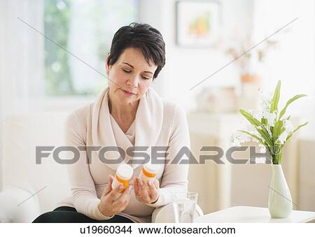 Portrait of mature woman looking at pill bottles View Large Photo Image Picture - Portrait of mature woman looking at pill bottles. Fotosearch