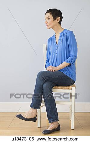 Portrait of mature woman sitting on chair View Large Photo Image Stock Photograph - Portrait of mature woman sitting on chair. Fotosearch