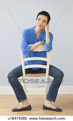 Portrait of mature woman sitting on chair View Large Photo Image Stock Photography - Portrait of mature woman sitting on chair. Fotosearch
