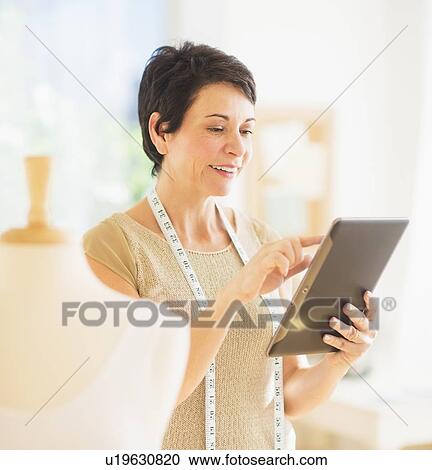 Portrait of mature woman with clothing bust using digital tablet View Large Photo Image Stock Image - Portrait of mature woman with clothing bust using digital tablet. Fotosearch