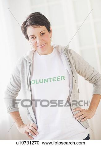 Stock Image - Portrait of mature woman with heads on hip. Fotosearch