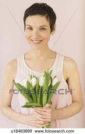 Stock Photo - Portrait of mature woman with tulips. Fotosearch