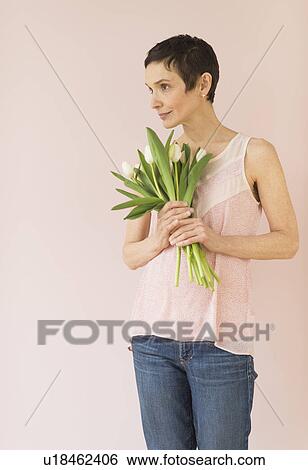Stock Photograph - Portrait of mature woman with tulips. Fotosearch