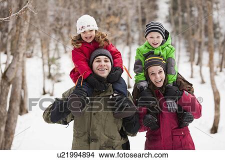 Picture - Portrait of parents carrying children (2-3, 4-5) on shoulders . Fotosearch