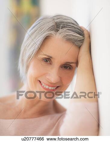Stock Photograph - Portrait of relaxed woman leaning against wall. Fotosearch