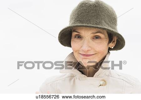 Stock Photograph - Portrait of smiling woman wearing raincoat and hat. Fotosearch