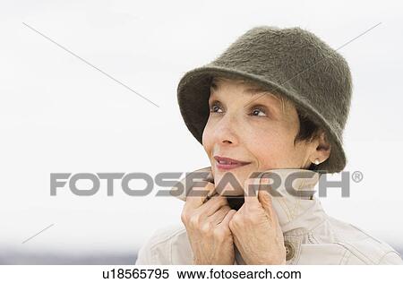 Portrait of smiling woman wearing raincoat and hat View Large Photo Image Stock Photography - Portrait of smiling woman wearing raincoat and hat. Fotosearch