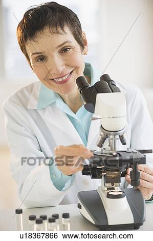 Portrait of smiling woman working with microscope in laboratory View Large Photo Image Stock Photograph - Portrait of smiling woman working with microscope in laboratory. Fotosearch