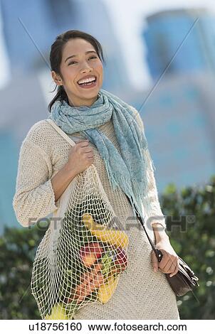 Portrait of smiling young woman with grocery shopping bag View Large Photo Image Stock Image - Portrait of smiling young woman with grocery shopping bag. Fotosearch