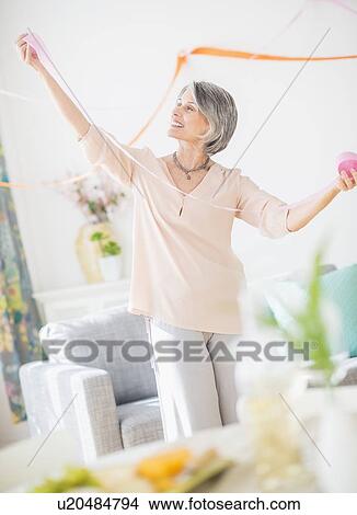 Portrait of woman decorating living room View Large Photo Image Picture - Portrait of woman decorating living room. Fotosearch