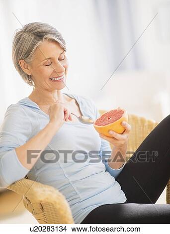 Portrait of woman eating grapefruit View Large Photo Image Picture - Portrait of woman eating grapefruit. Fotosearch