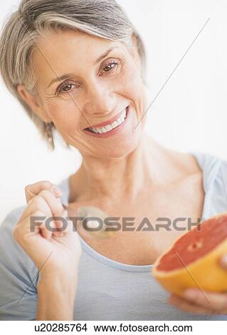 Portrait of woman eating grapefruit View Large Photo Image Picture - Portrait of woman eating grapefruit. Fotosearch