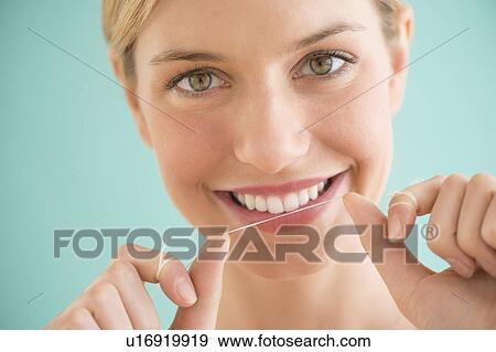 Portrait of woman flossing teeth View Large Photo Image Stock Photo - Portrait of woman flossing teeth. Fotosearch