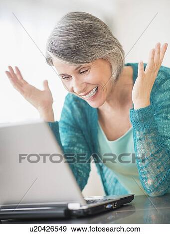Portrait of woman gesturing in front of laptop View Large Photo Image Stock Photo - Portrait of woman gesturing in front of laptop. Fotosearch