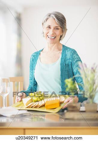 Stock Image - Portrait of woman holding appetizer plate. Fotosearch
