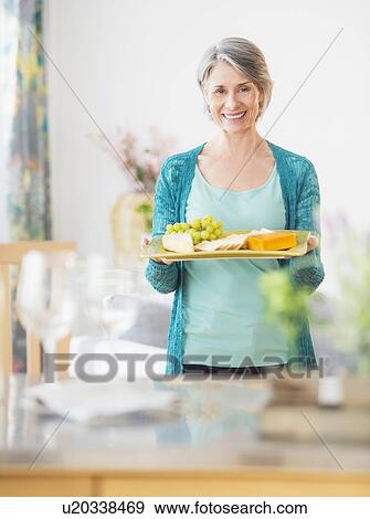 Stock Photo - Portrait of woman holding appetizer plate. Fotosearch